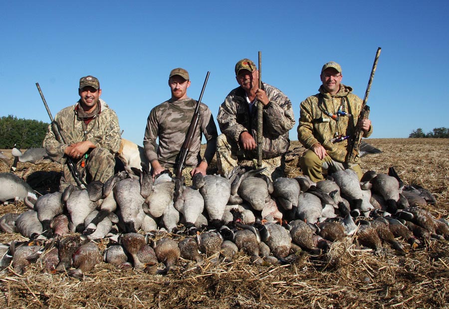Goose and duck hunting in Alberta, these four happy sportsmen pose with their catch.